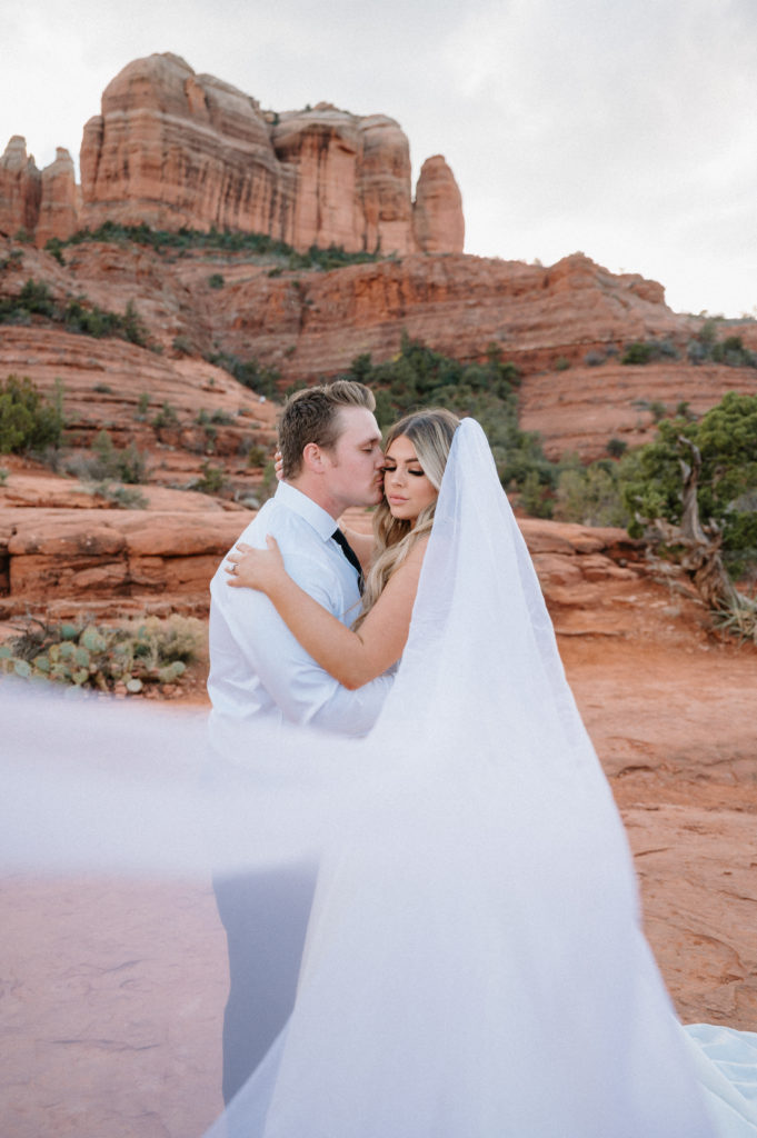 Adventurous elopement photography in Sedona Arizona with towering desert cliffs.