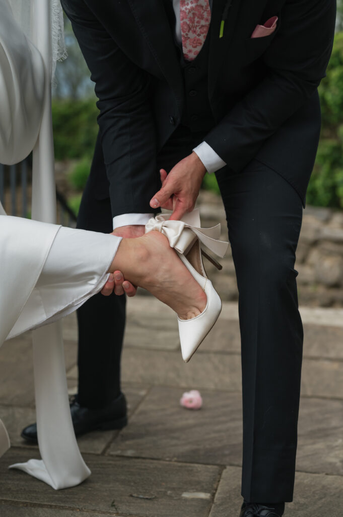 Groom fixes bride's shoe at Cheekwood Estate in Nashville, TN.