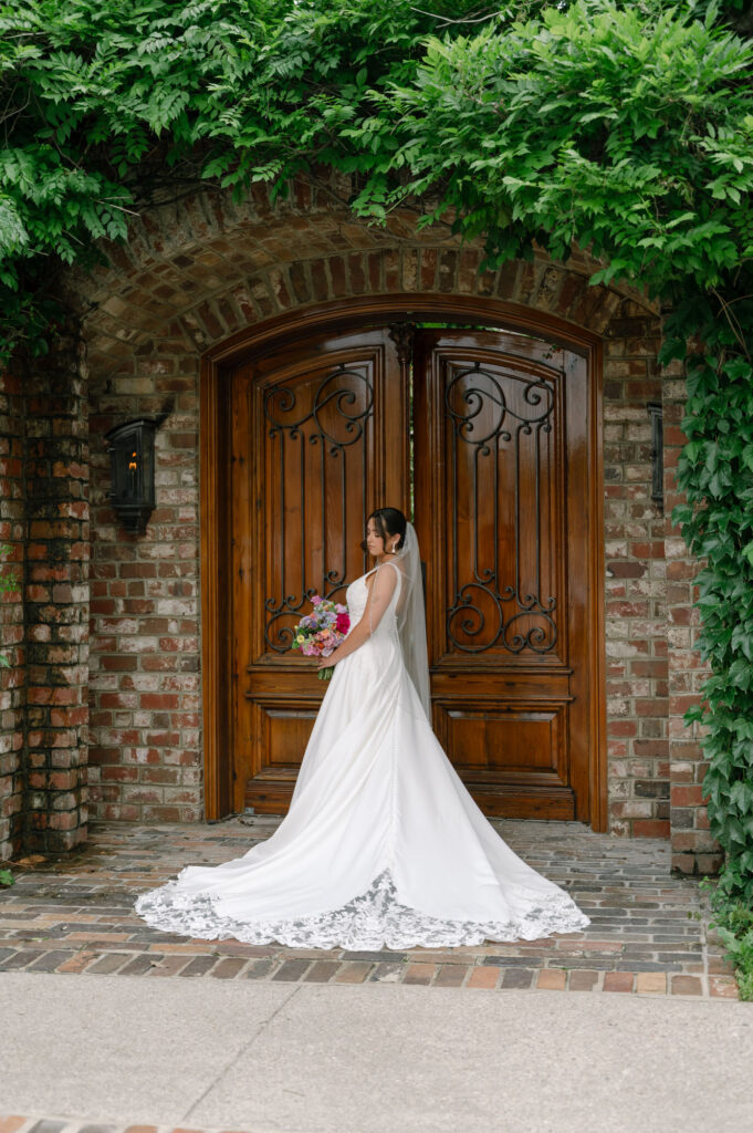 bride holding bouquet in front of doors at the apiary, wedding venue in lexington kentucky, taken by Keely Nichole Photography