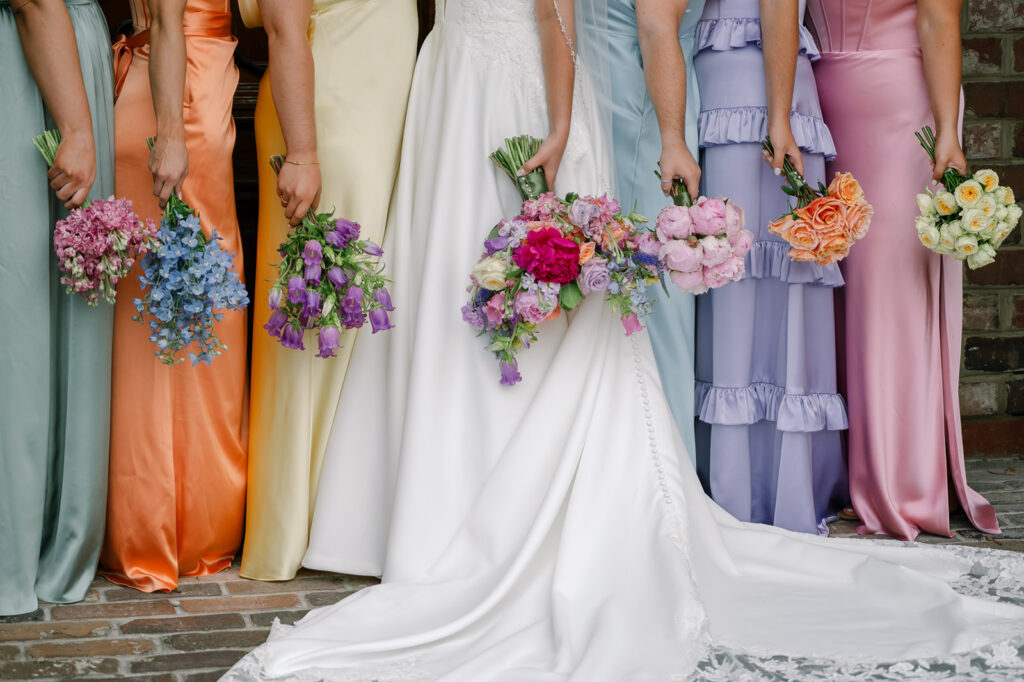 Bride and bridesmaids holding colorful bouquets at The Apiary Lexington.