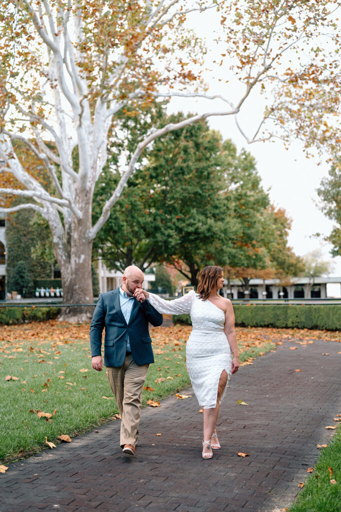 Two people walking hand in hand near large tree at a Keeneland wedding venue