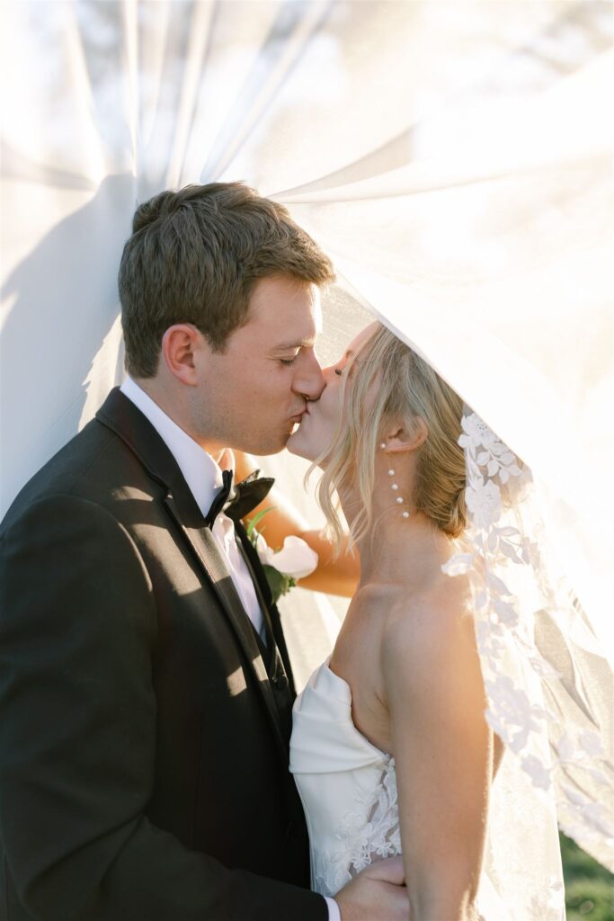 Bride and groom share a kiss under the veil at Lexington Country Club, a country club in Lexington, KY. 