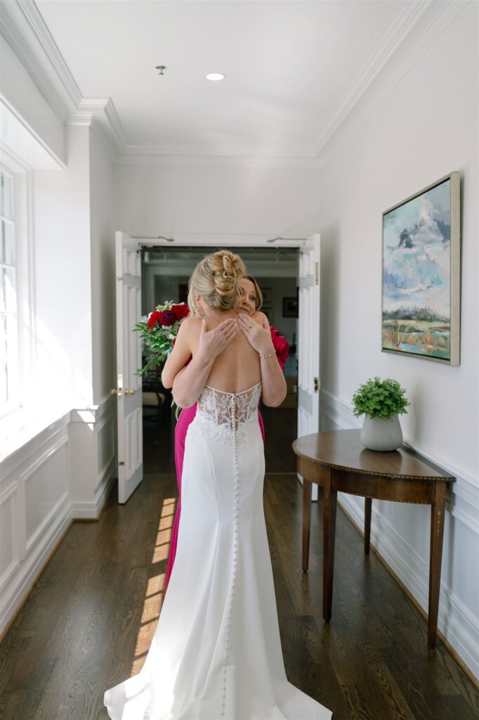 Bride and mom embrace at  Lexington country club wedding. 