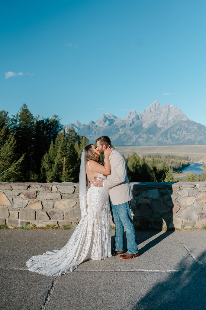 Couple walking through a valley with the Tetons rising in the background.