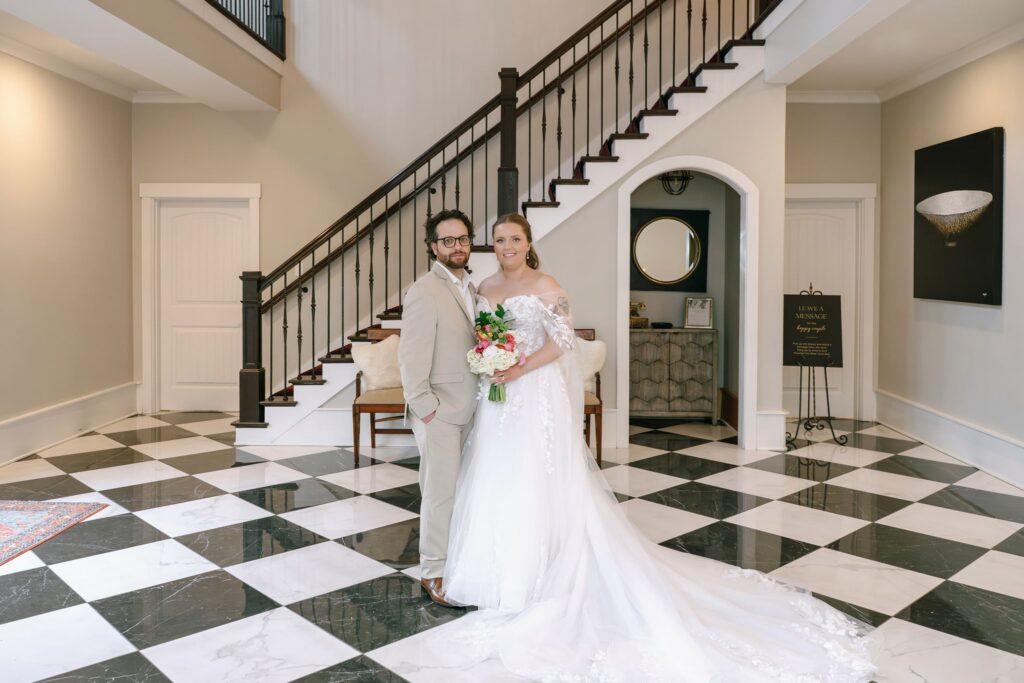 Bride and groom posing inside the elegant reception space at their Hazelnut Farm wedding. 