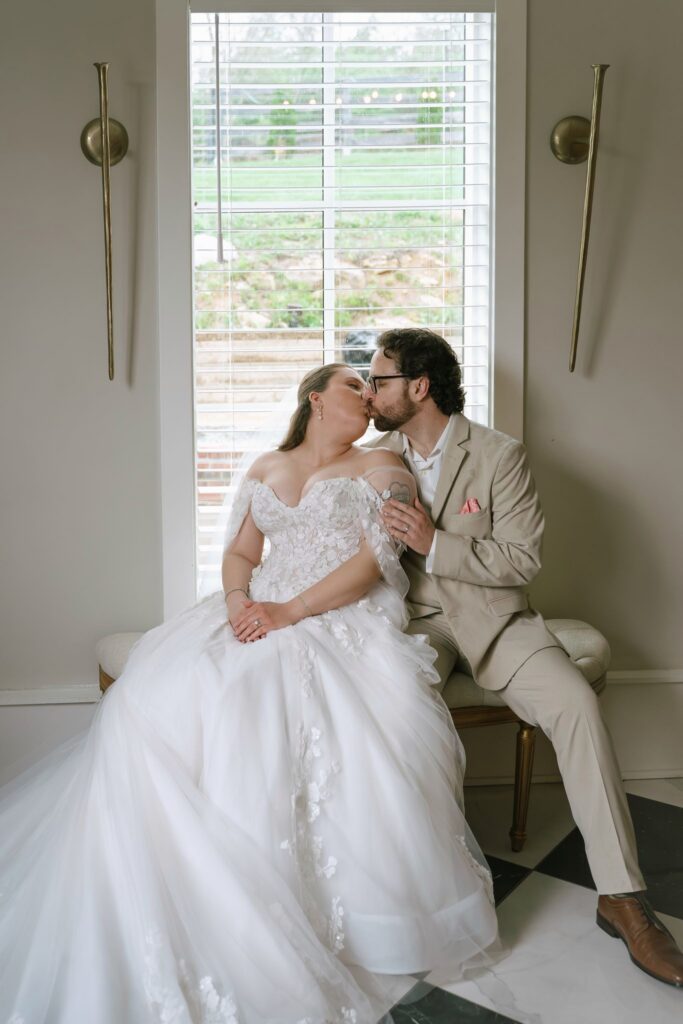 Bride and groom sharing a quiet kiss indoors during their Hazelnut Farms wedding. 