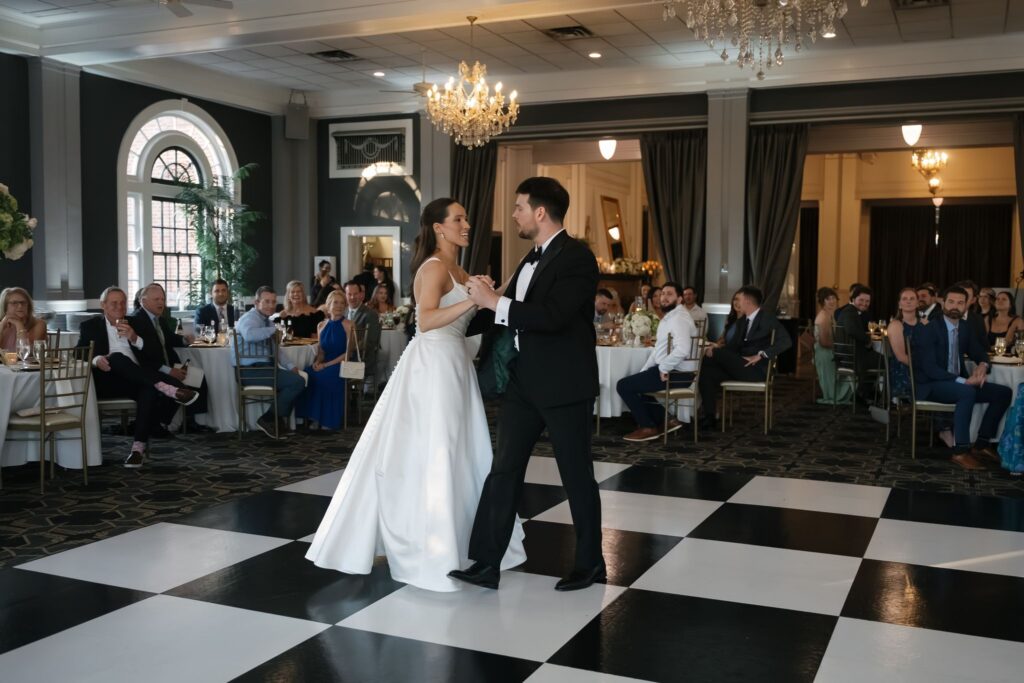 Bride and groom sharing their first dance beneath sparkling chandeliers at a historic wedding venue in Louisville KY.