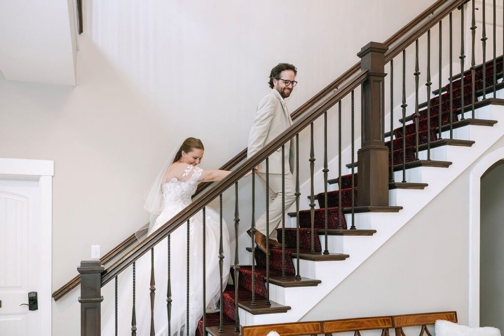 Groom and bride laughing while walking up a winding staircase at Hazelnut Farms, an outdoor wedding venue in Louisville, KY.