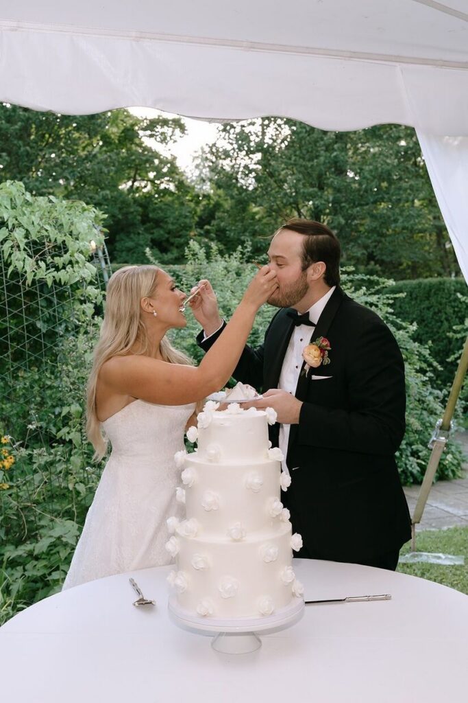 Bride and groom feeding each other a bite of cake at the Whitehall wedding venue. 